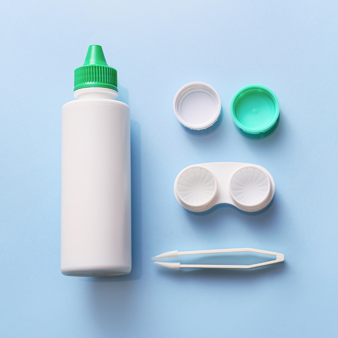 Contact lens solution, contact lens case with contact lenses, and tweezers on a blue background